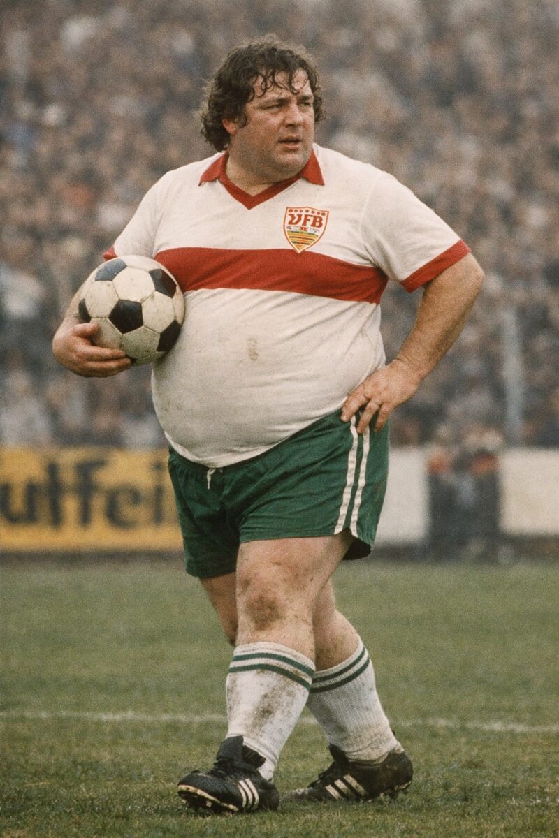 Johann Buffy Ettmayer im VfB-Trikot mit dem Ball unter dem Arm — KI-generierte Illustration des legendären VfB-Stürmers der 1970er Jahre
